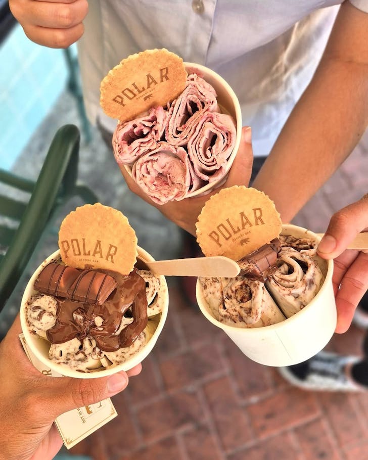 People holding tubs of Polar Dessert Bar gelato, including their famous hand-rolled offering. 