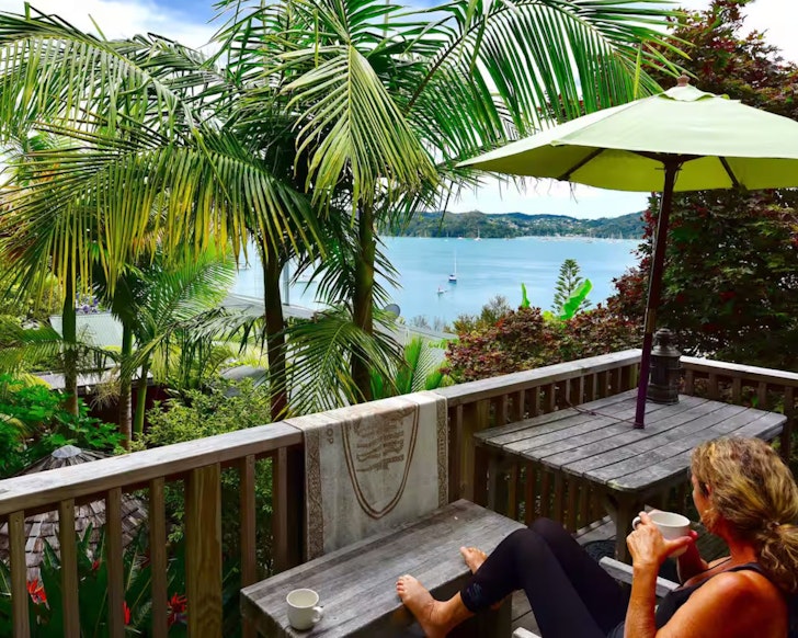 A woman looks out to sea at Polynesian Beach Loft On The Bay one of the best beach house Airbnbs NZ