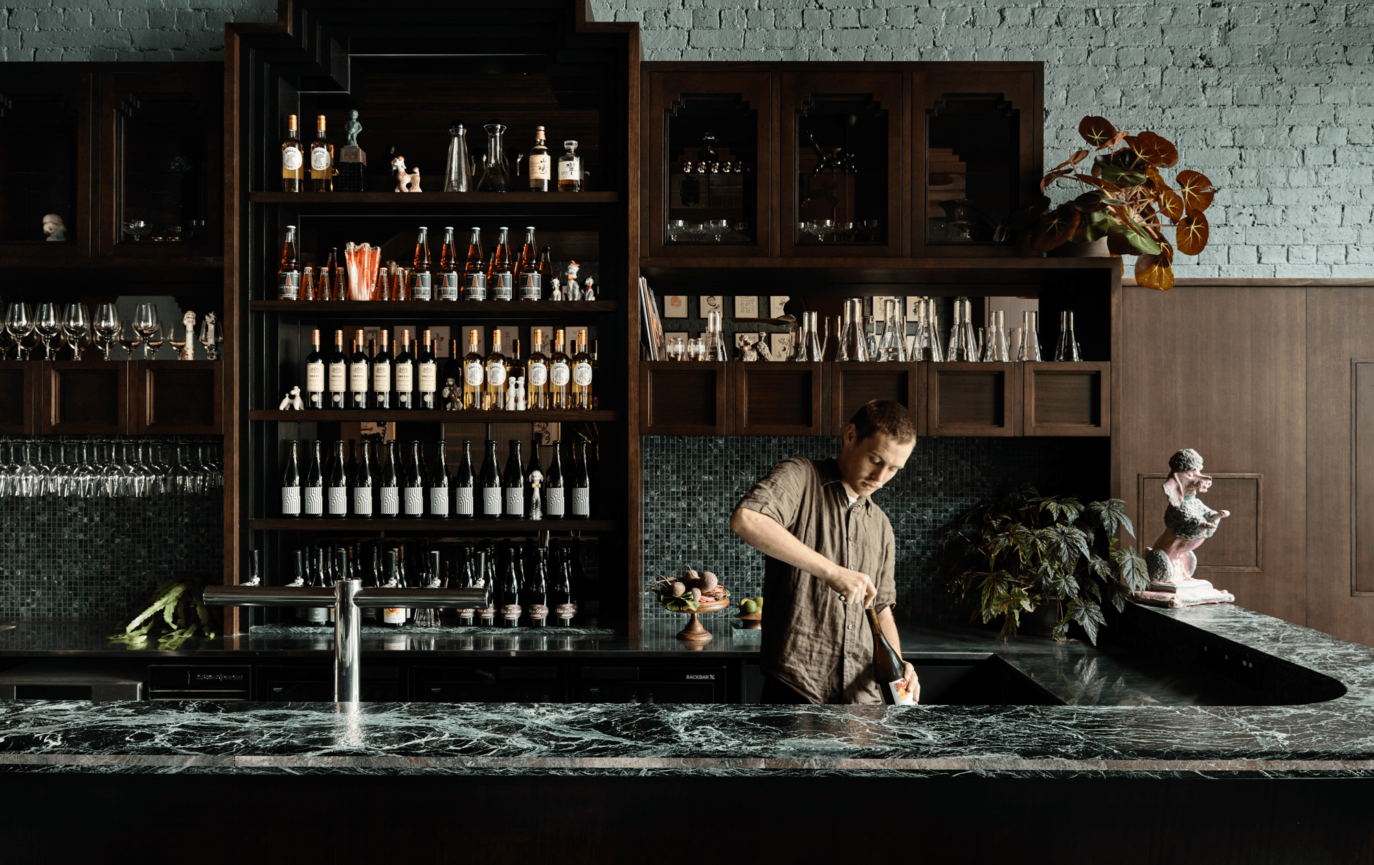 A person standing at a green marble bar, a best cocktail bar melbourne contender