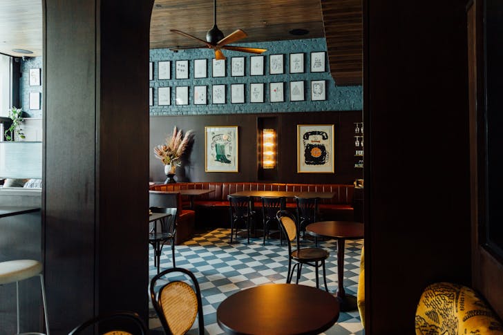 A checkered floor and green couch inside a restaurant with a top private dining room Melbourne.