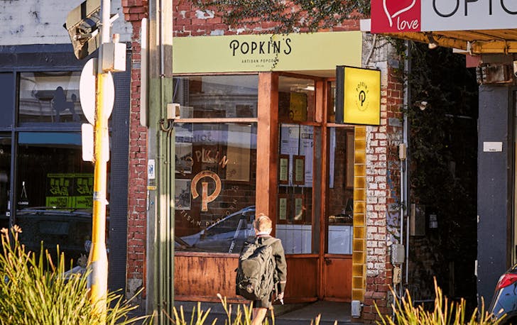 The front of a store with a person walking in front. 