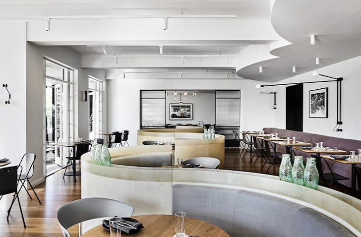 A spacious dining room with a S-shaped booth in the centre at one of the best St kilda restaurants, Prince Dining Room