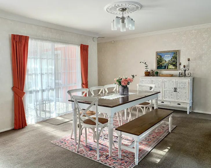 A vintage style table and chair arrangement sit in a spacious dining room at a North Hamilton airbnb. 