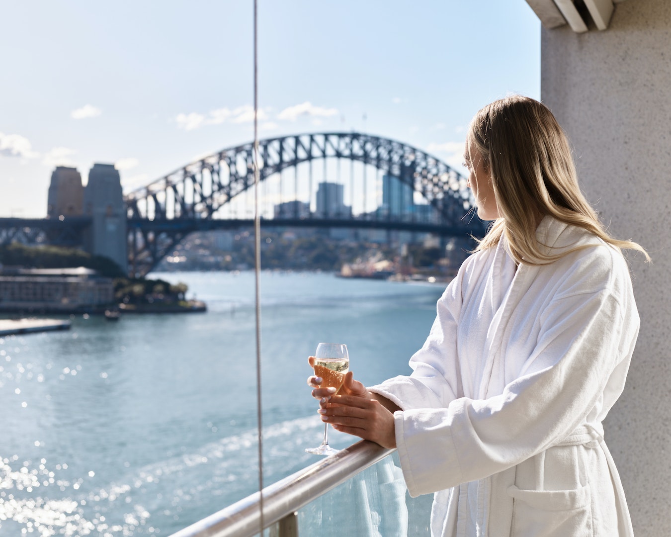 A person overlooking Sydney Harbour at the Pullman Quay Grand hotel, one of the best hotels in Sydney