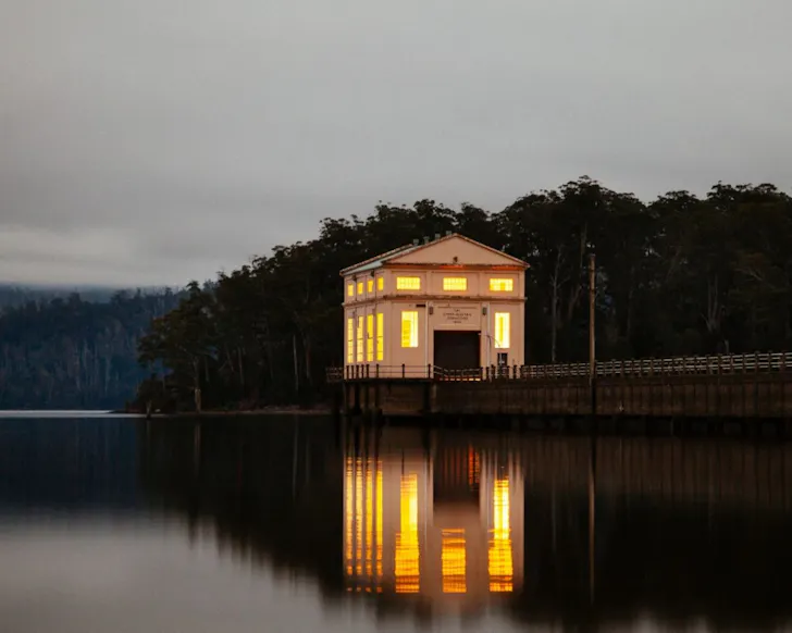A view of Pumphouse Point lakehouse surrounded by water at dusk in Tasmania