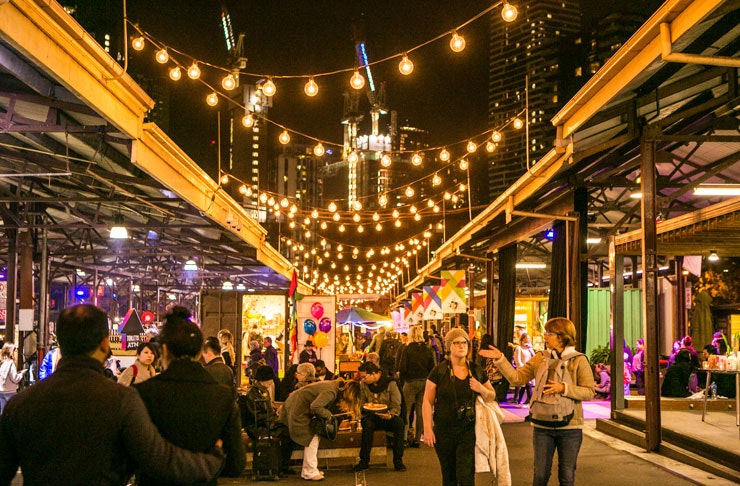 people walking through the sheds of Queen Vic Night Market.