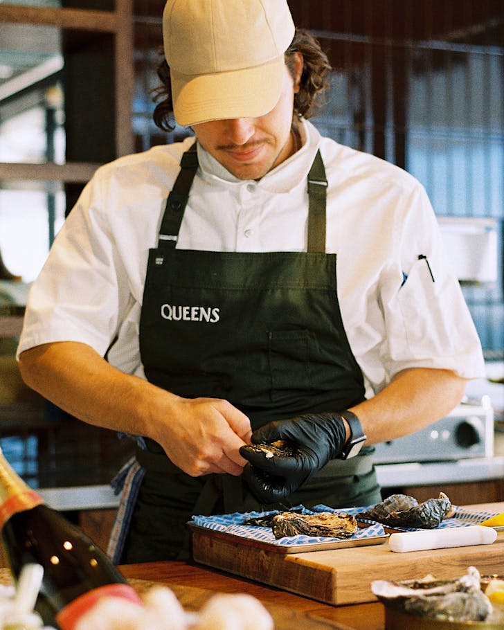A chef preps a dish at Queens Rooftop. 