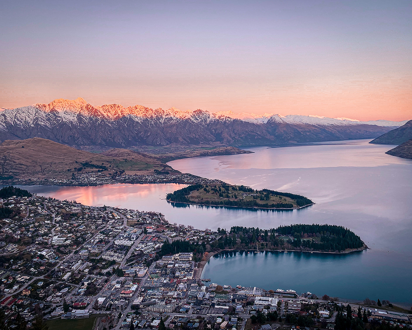 An aerial view of Central Queenstown under a gorgeous purple sky.