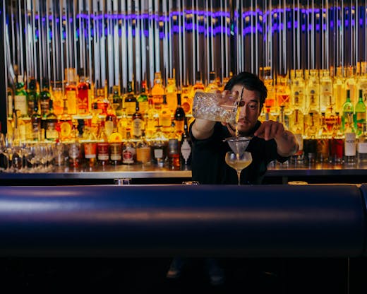 Quinn makes a cocktail behind the bar at Quinn