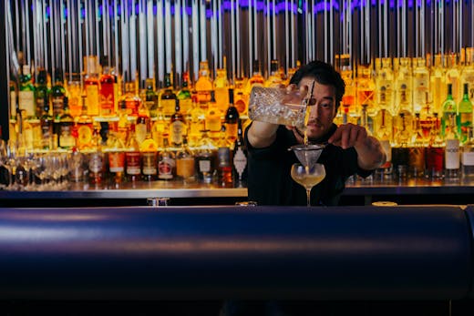 Quinn makes a cocktail behind the bar at Quinn
