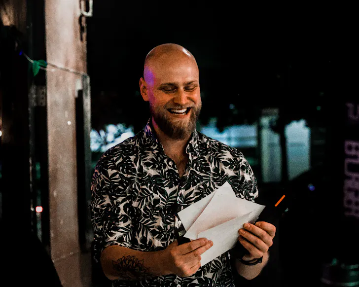 Seb Mayr, host of QuizHaus NZ, flicks through note cards.