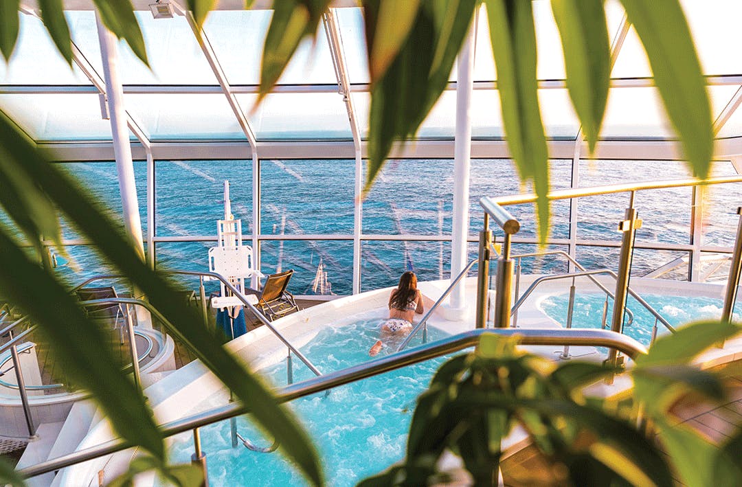 Woman in a pool on a cruise ship looking out to the ocean