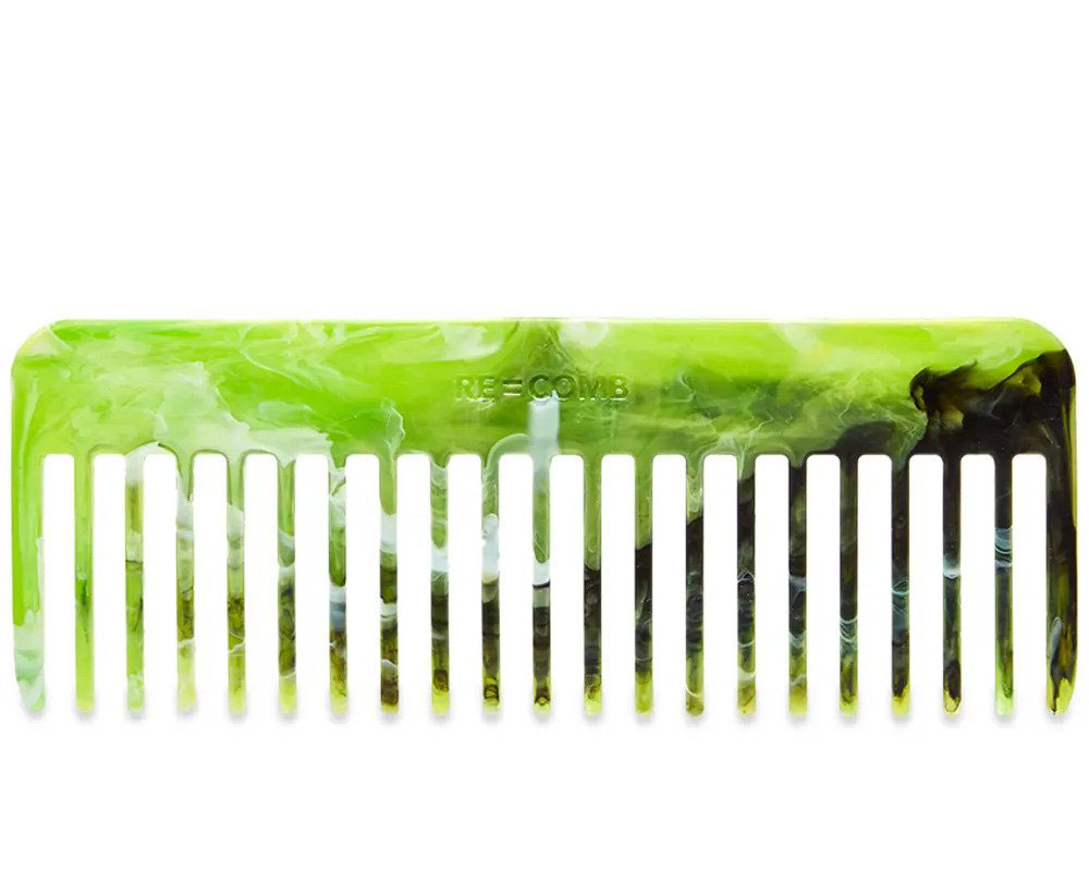 A bright green wide-tooth hair comb with white and black marbling.