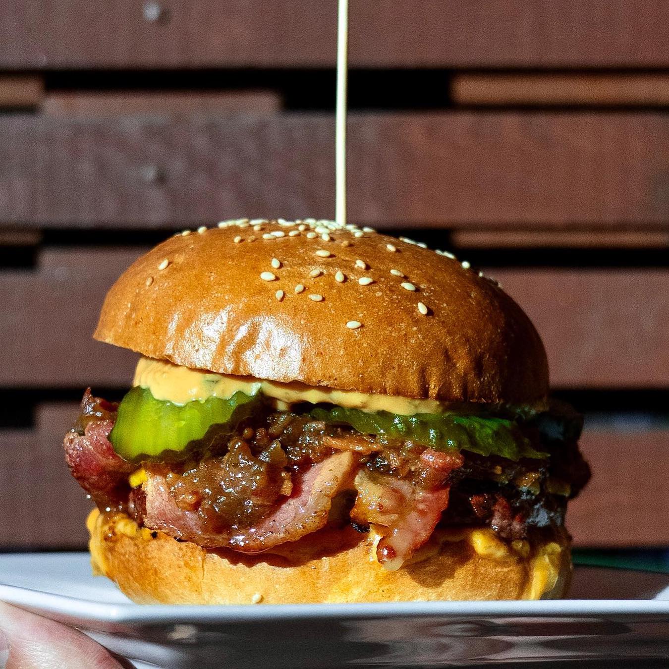 Burger with beef, bacon, American cheddar, pickles and bacon onion jam from Redstar burger, one of the best restaurants in Wanaka.