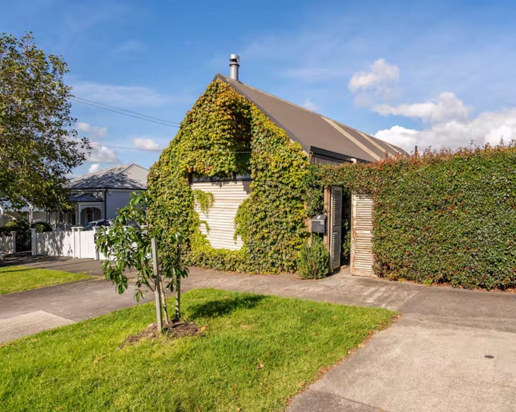 The ivy-clad exterior of Repurposed Mechanics Workshop one of the best Auckland Airbnbs