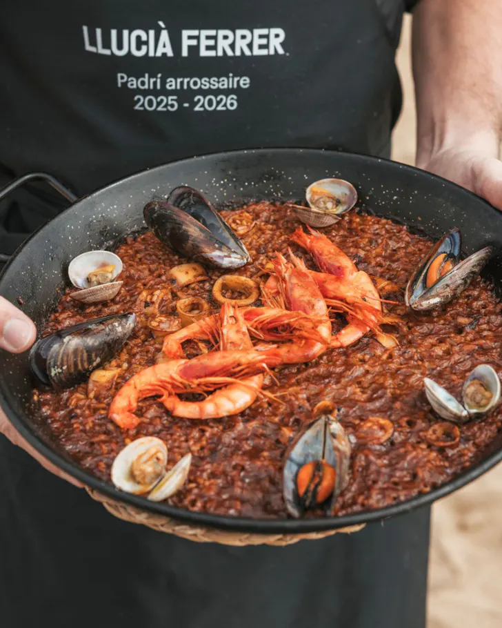 A waiter holding a steaming bowl of paella in Restaurant Arrozal.