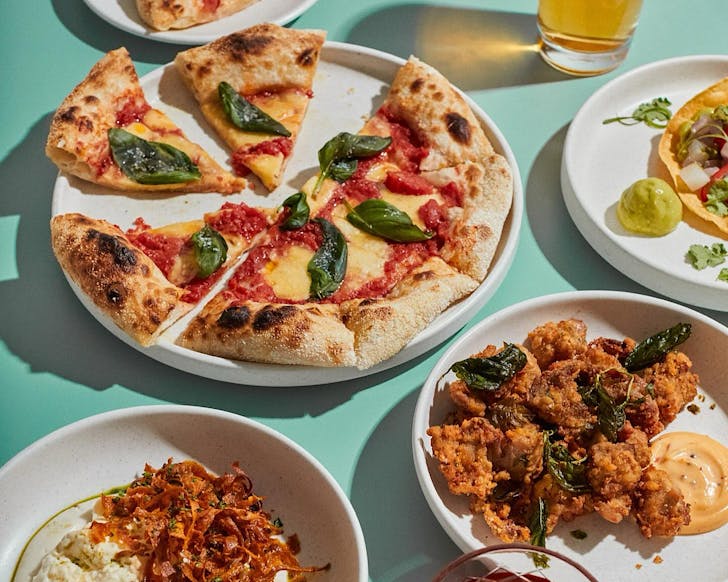 A delicious spread of pizza, fried chicken, and beer. 