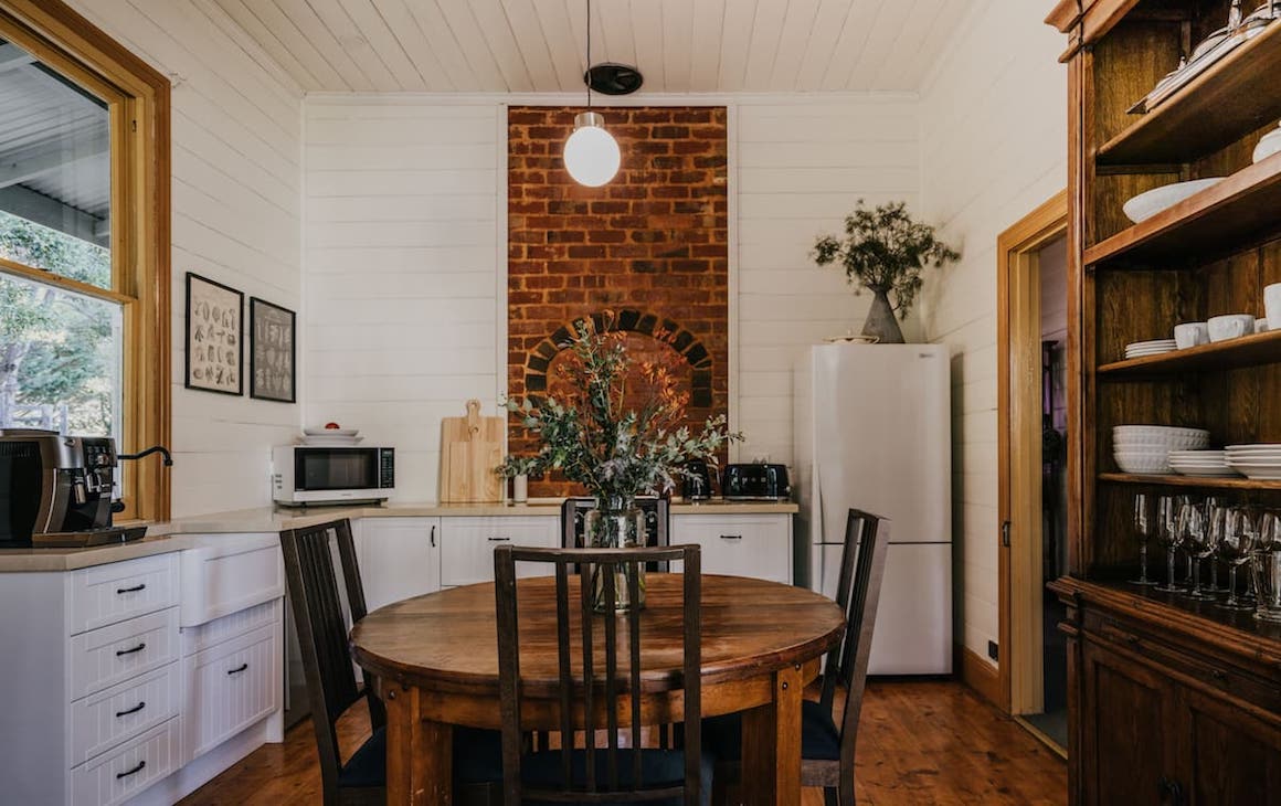 A white-painted and brick kitchen of one of the best romantic getaways in Victoria.
