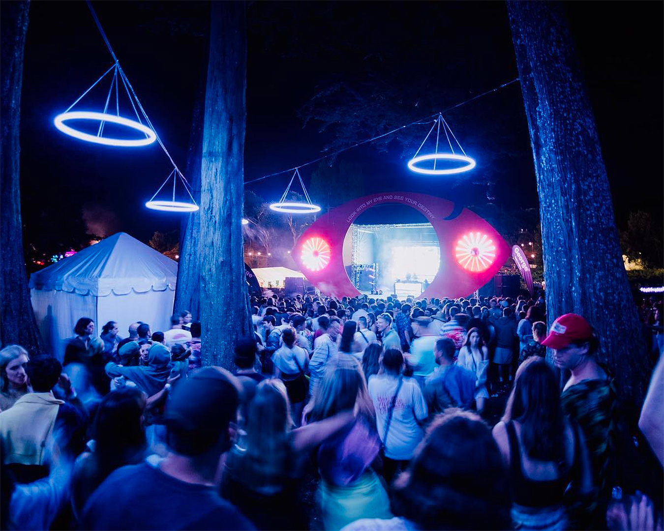 People mill about under blue lights at Rhythm & Vines, another of the best New Year’s Eve parties in New Zealand. 