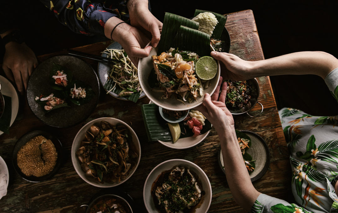 A table with people sharing food at one of Melbourne's best Thai food. 