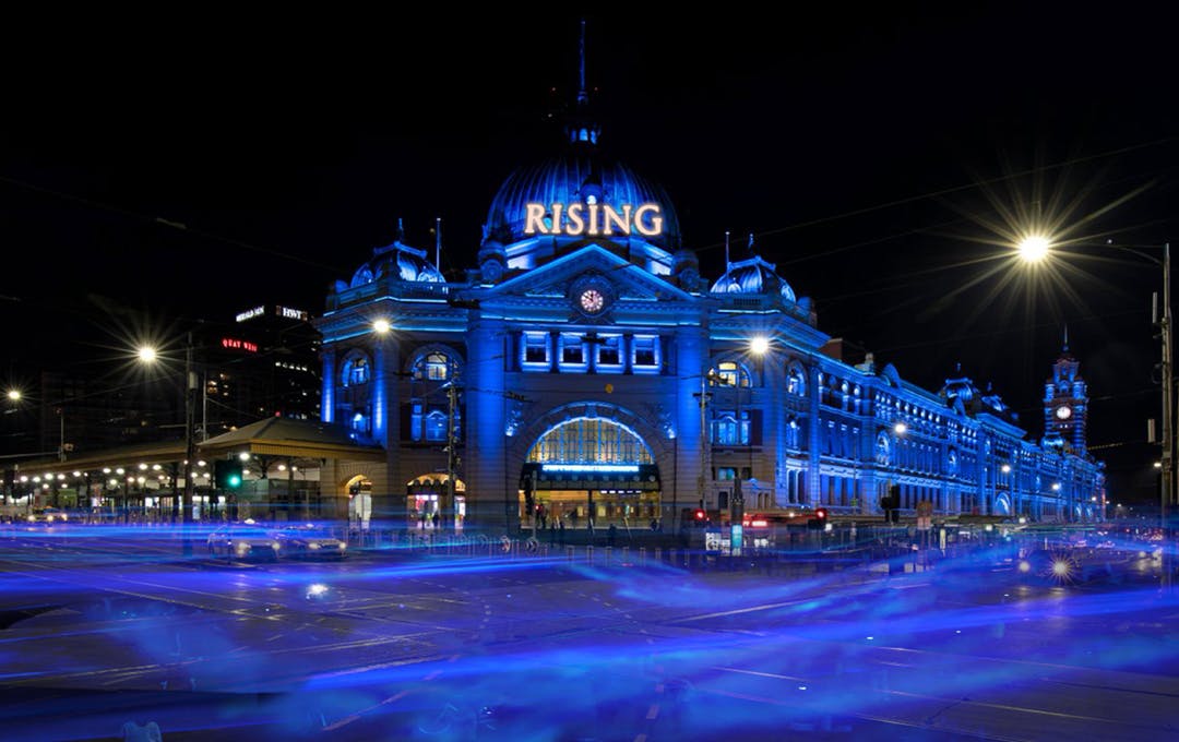 Federation square lit up in blue for Rising Festival Melbourne. 