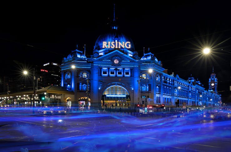 Federation square lit up in blue for Rising Festival Melbourne. 