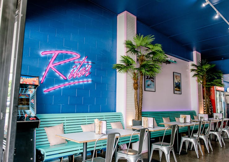 an 80s inspired diner with a pink neon sign that says 