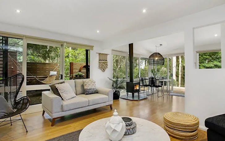 A lounge room with a large fireplace, a best Lorne accommodation option.