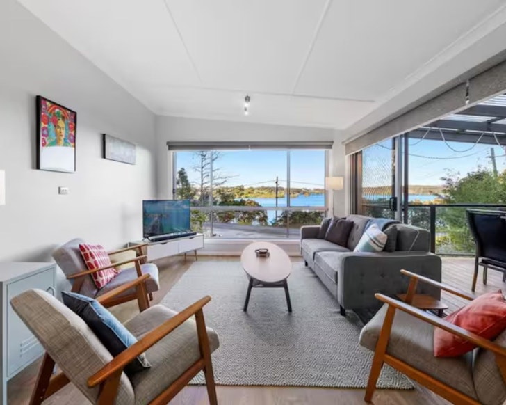 A view of the living space with a water view at Riverview Beach House Airbnb one of the best accommodation options in Narooma NSW