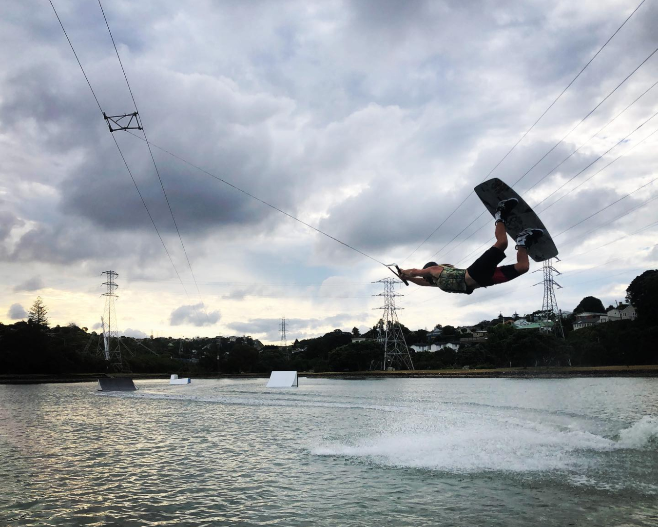 A person catches some air over Onehunga Bay Lagoon using the revolutionary Rixen cable wakeboarding system. 