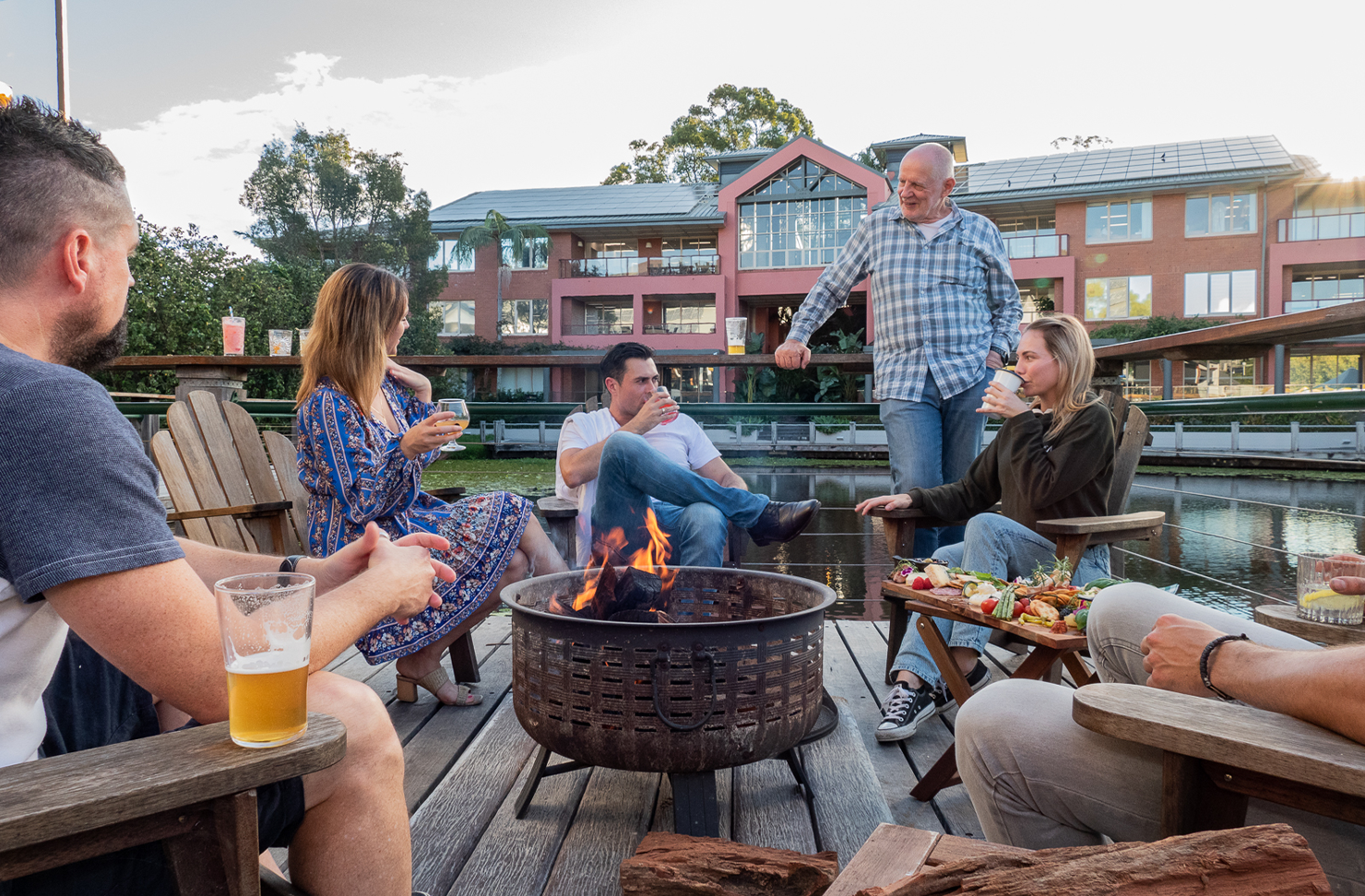 people gathered around a lakeside fire pit