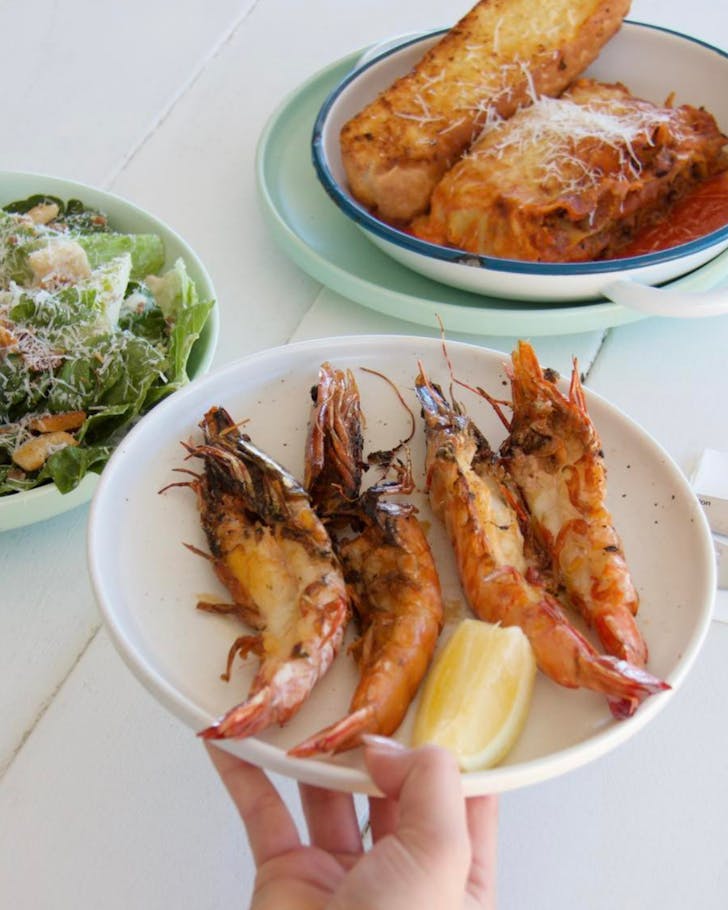 A plate of prawns, lasagne and caesar salad served at the Rockpool Pavilion in Townsville.