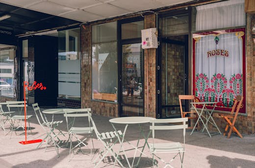 The exterior of Roses Dining Room and a red wire Roses sign in cursive. 
