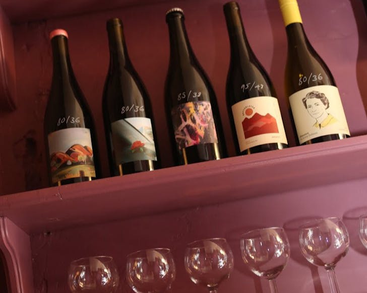 A shelf of pretty bottles and glasses at Roses Dining Room. 