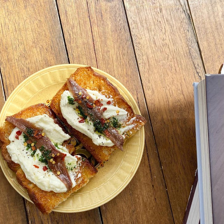 Anchovy on toast on plate.
