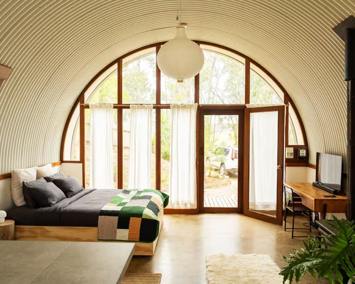 The bed underneath the round roof of Round House Retreat tiny home NSW
