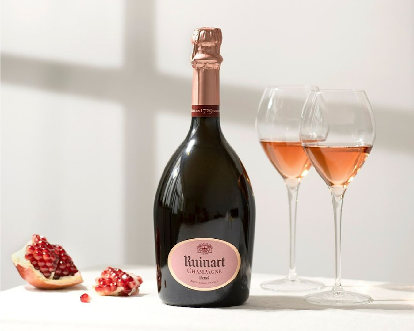 A bottle of Ruinart rosé, two full glasses and a pomegranate - smashed, like your ex’s heart when they realise they dumped the best thing that ever happened to them. 