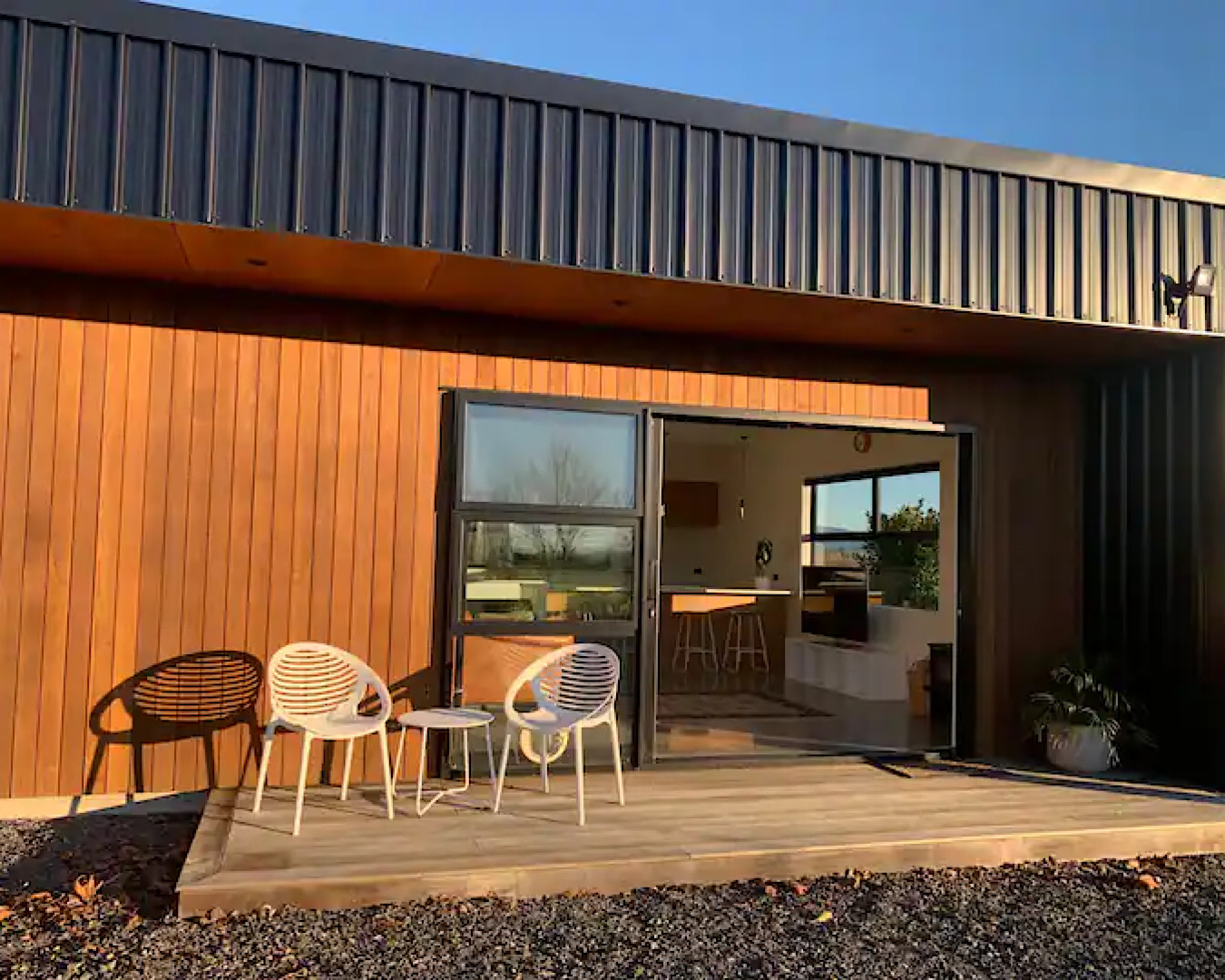 The sunlit entrance to a wooden studio that looks very inviting. 