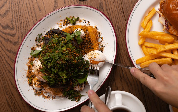 A plate full of dukkah, poached eggs and greens from Rustica, one of the best breakfasts in Melbourne