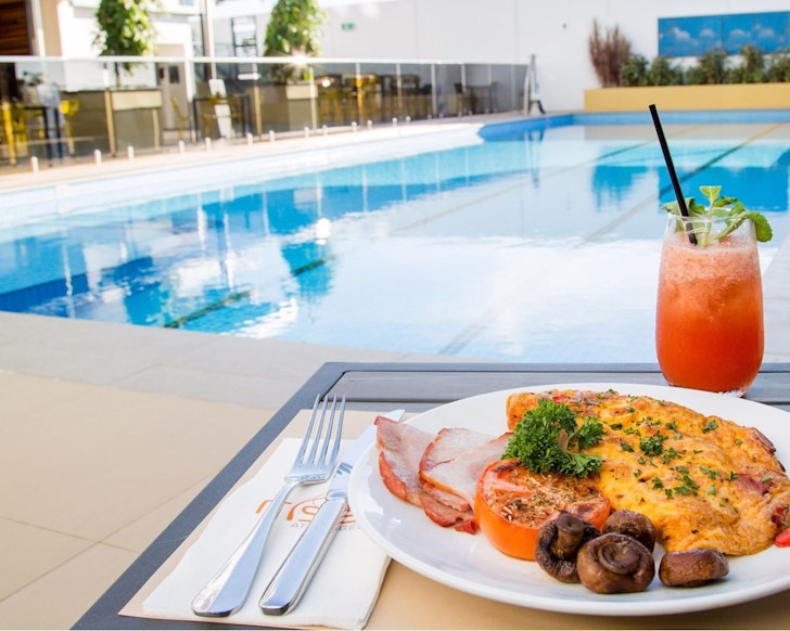 A plate of breakfast by the pool at Rydges Palmerston one of the best Darwin hotels