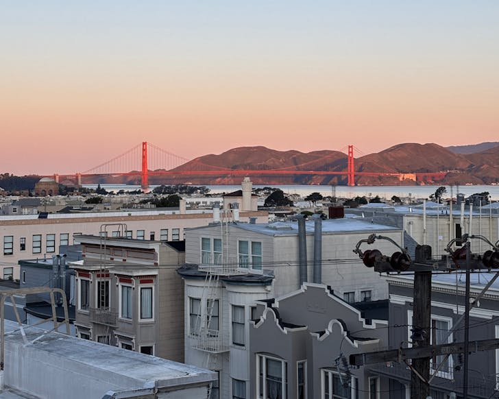 Sprawling city with red bridge at end. 
