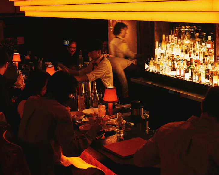 Dark room with people sitting at bar