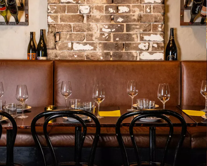 Three tables with wine bottles behind