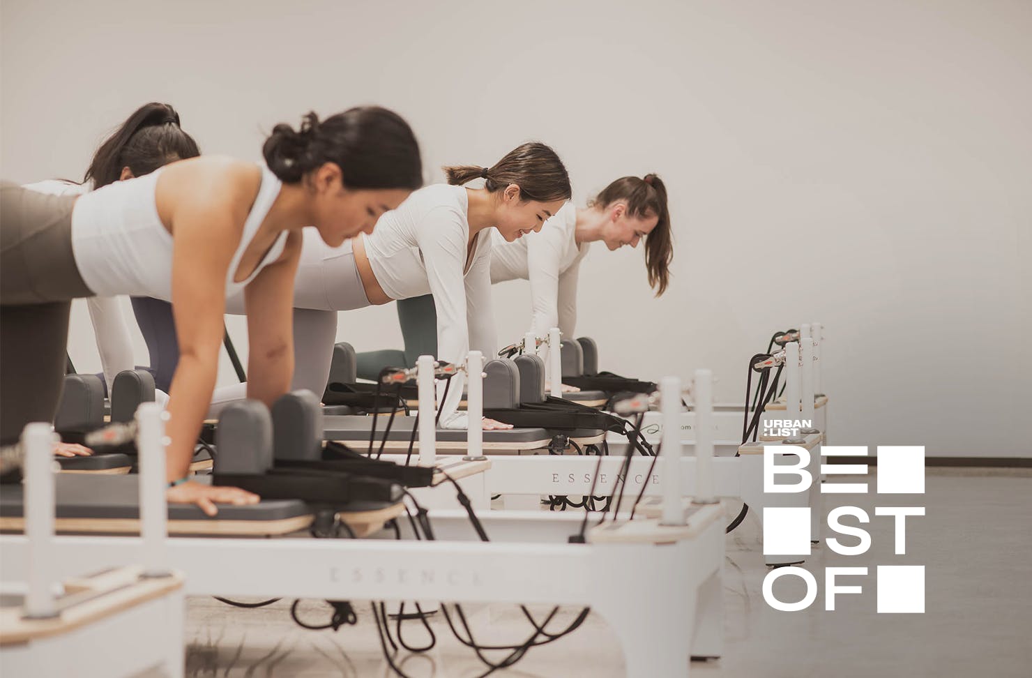 Three women do pilates on reformers at SO Fitness, one of Auckland's best pilates studios. 