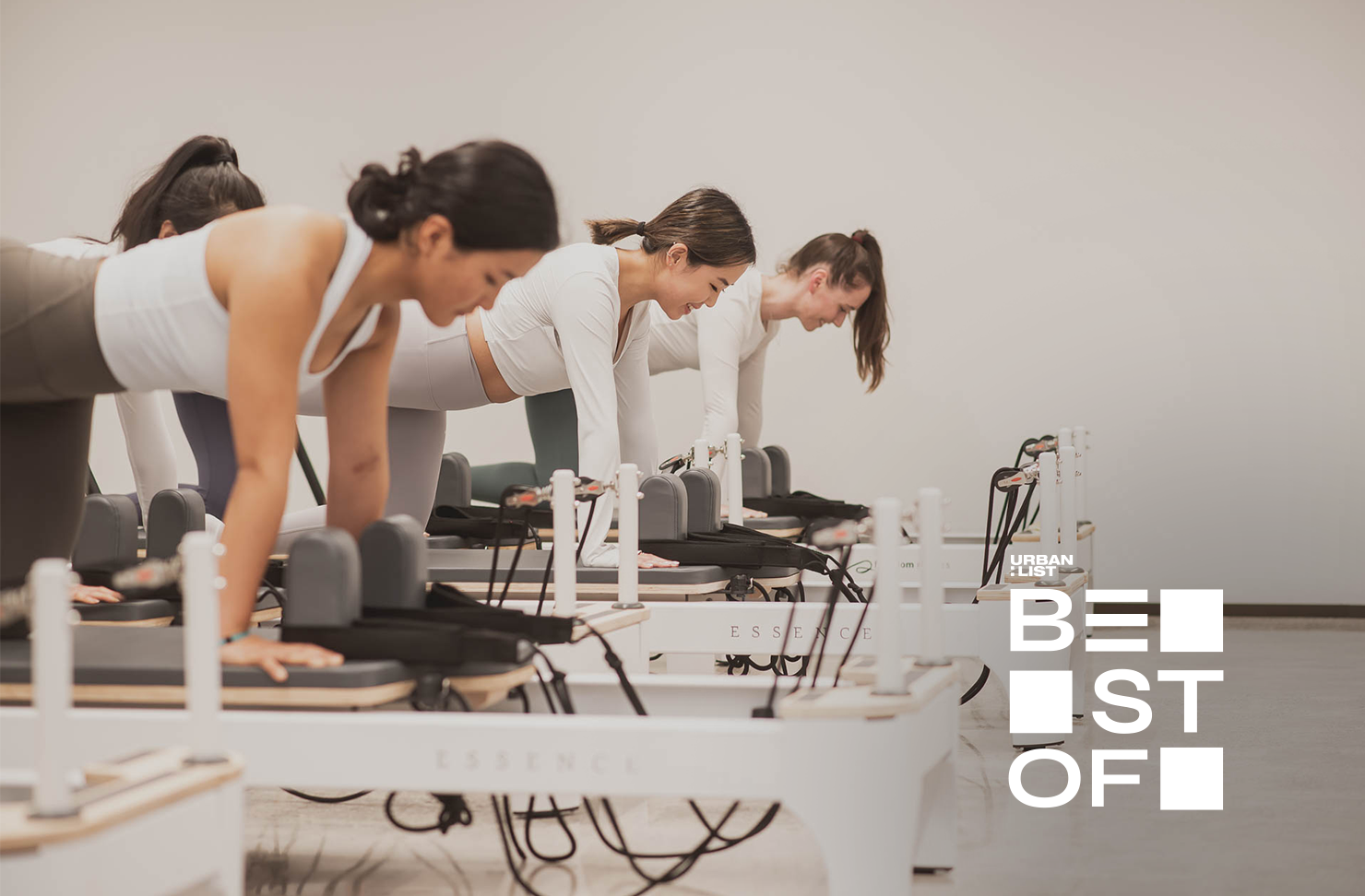 Three women do pilates on reformers at SO Fitness, one of Auckland's best pilates studios. 