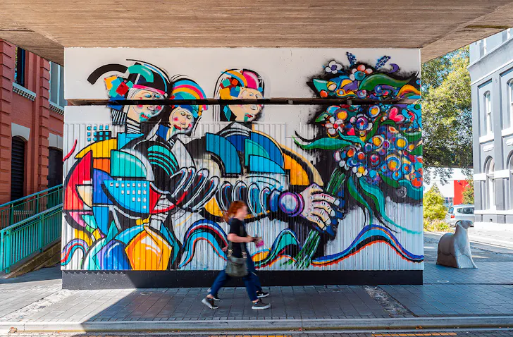 People pass by cool artwork in Dunedin, one of the best things to do in Dunedin.