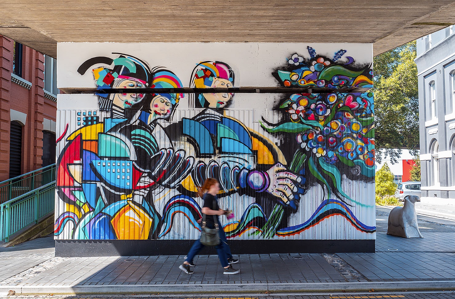 People pass by cool artwork in Dunedin, one of the best things to do in Dunedin.
