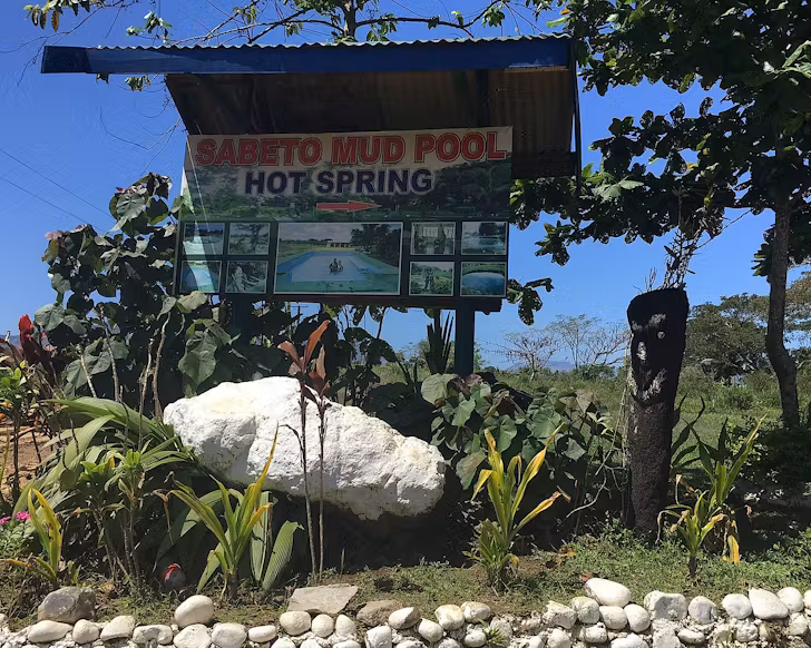 An old school sign entrance to Sabeto Mud Pool Hot Spring