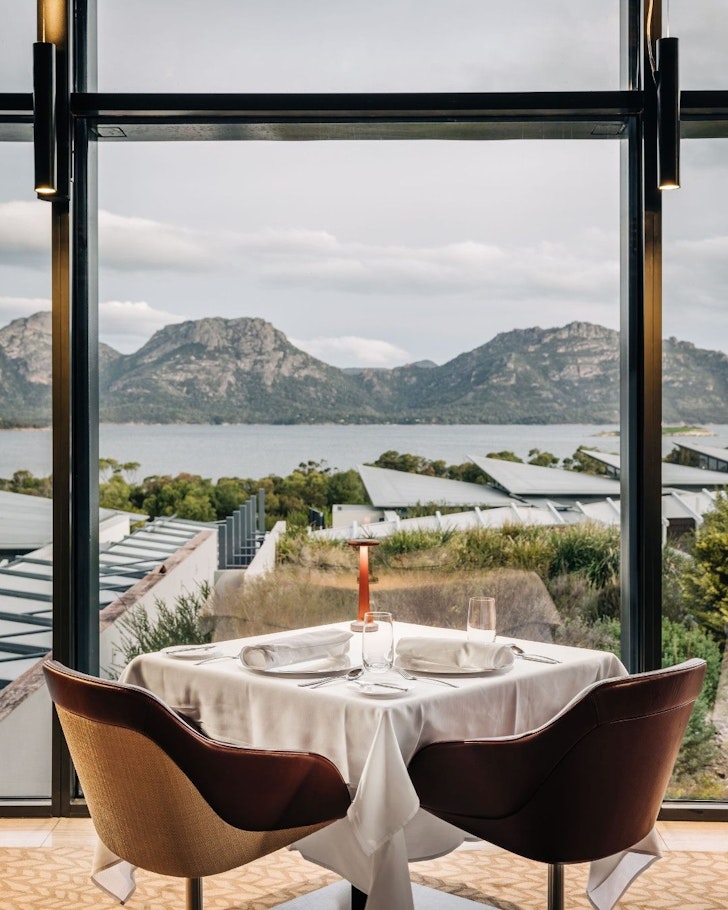 A view of a table in the restaurant overlooking the water and mountains at Saffire Freycinet one of the best romantic getaways in Australia
