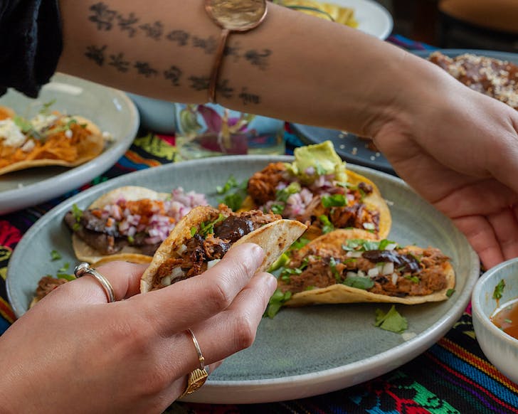 Vicki reaches for a bowl of consomme to dunk her taco.